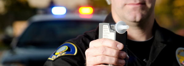 Police officer holding alcotest machine for breath test